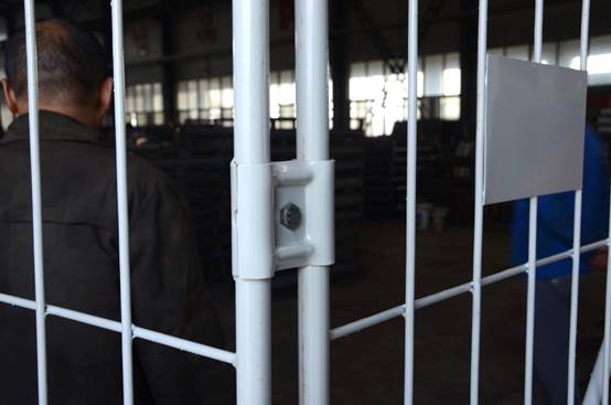 A detailed view of the locking mechanism on a roll cage container.