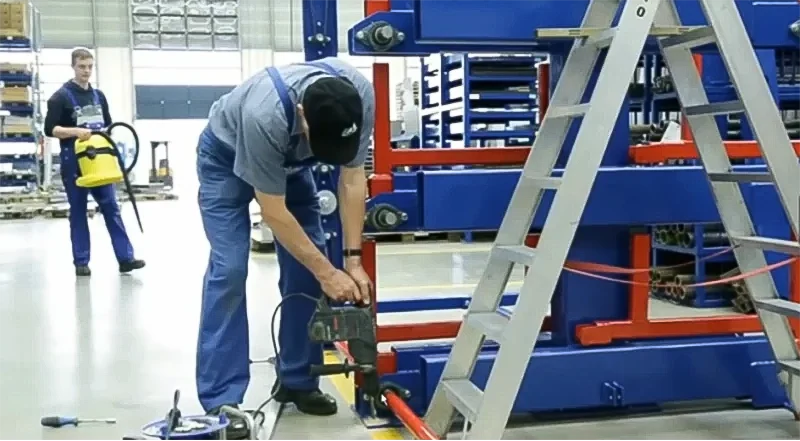 Installation team drilling concrete anchors for rack stability