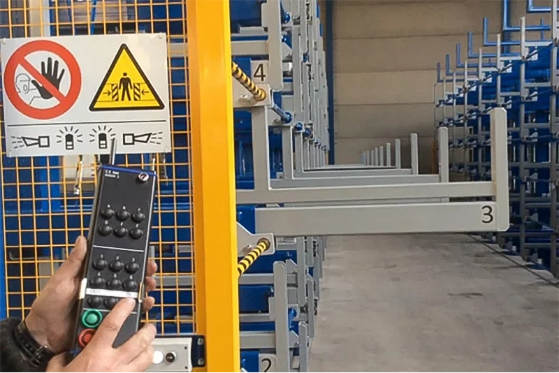 Operator using remote control for motorized telescopic cantilever rack