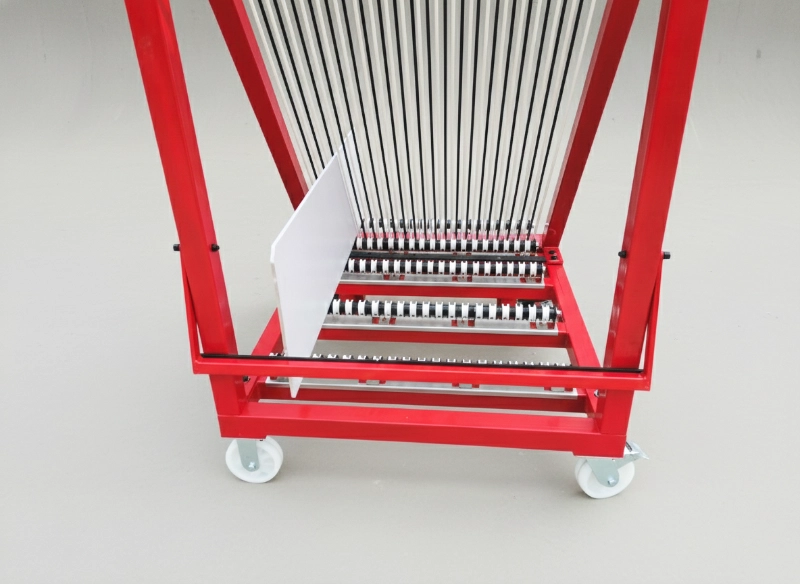 A red harp rack for glass, fully assembled and ready for use in a glass fabrication workshop.